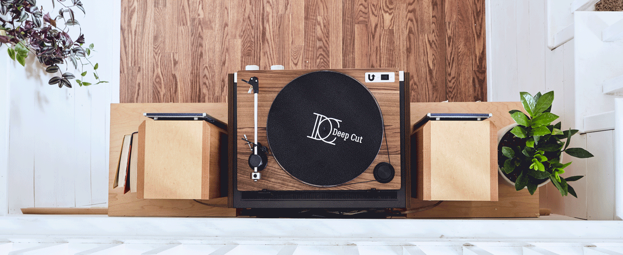 A U-Turn Orbit Special turntable in walnut sitting on top of wall mounted cube record shelves